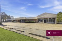 Large commercial building with parking lot and main entrance