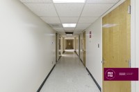 Hallway with multiple offices and fluorescent ceiling lighting